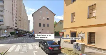 Črn avto parkiran ob problematičnem košu za smeti in prometnem znaku