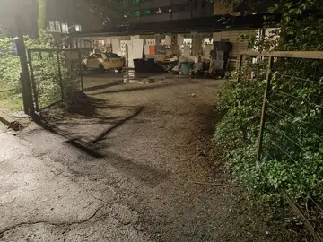 Odprta vrata na dvorišče z avtom in raztresenimi predmeti ponoči