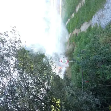 Dim in ogenj ob travnati poti s prometnim stožcem