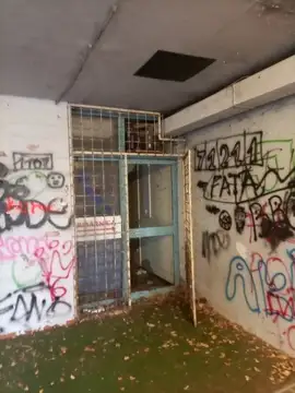 Z grafiti porisana stena in kovinska vrata v temnem hodniku