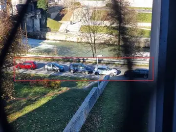 Pet avtomobilov parkiranih na ozki poti ob reki