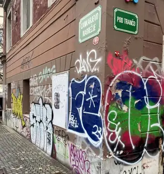 Grafiti na vogalu stavbe in zidu ob tlakovanem pločniku