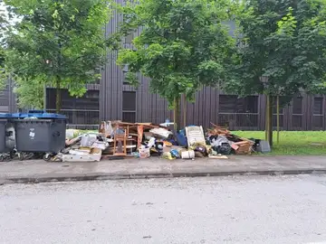 Velik kup mešanih odpadkov odvržen ob koših na pločniku