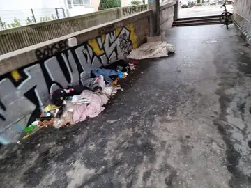 Smeti in odvržena oblačila v podhodu z grafiti