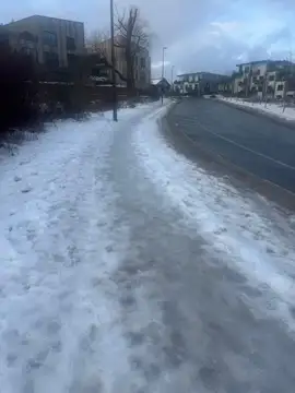 Sneg in led na pločniku ob cesti v stanovanjskem naselju