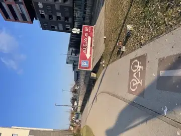 Pločnik z oznako za kolesarsko stezo in tablo za parkiranje
