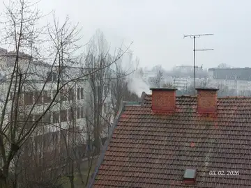 Dim iz dimnika na strehi stanovanjskega bloka