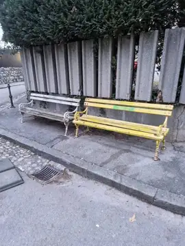 Dve stari klopi na razpokanem pločniku ob ograji in jašku