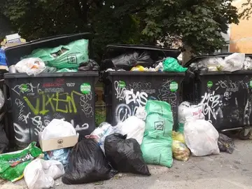 Prepolni koši za smeti z vrečami okoli njih