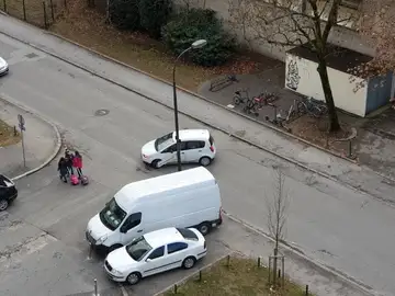 Kombi parkiran na križišču, pešci v bližini